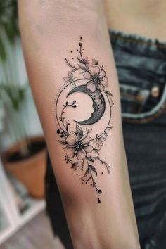 a woman's arm with a crescent and flowers on it