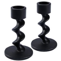 two black candlesticks sitting on top of each other