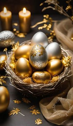 a basket filled with golden and silver eggs on top of a table next to candles