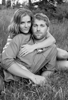 a man and woman sitting in the grass together