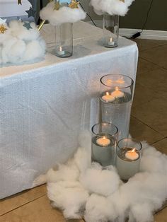 clouds and candles are on the table with white linen, which looks like cotton balls