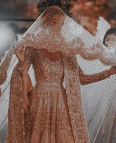 a woman in a wedding dress and veil is walking down the runway with her hands on her hips