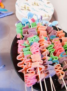 colorful marshmallows are arranged on a black plate