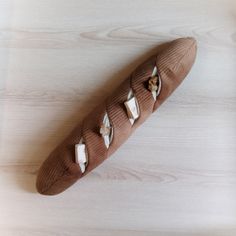 a piece of bread that is on top of a wooden table with some papers stuck to it