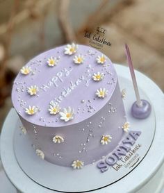 a birthday cake decorated with daisies and the words happy birthday written on the top