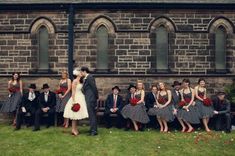 a bride and groom kissing in front of a group of people dressed up for a wedding