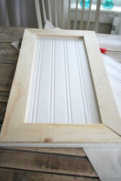 a white frame sitting on top of a wooden table