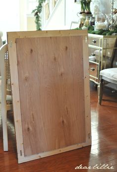 a wooden box sitting on top of a hard wood floor next to a white chair