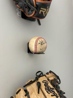 two baseball mitts and a catchers mitt hanging on the wall