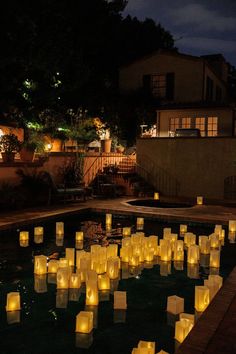 lighted paper lanterns floating in the water at night