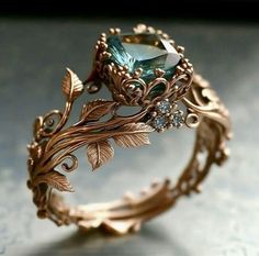 a close up of a ring on a table with leaves and stones in it's center