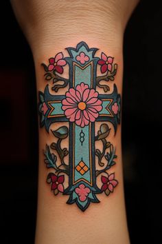 a cross tattoo with flowers on it