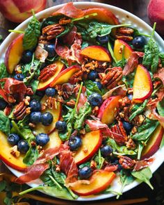 a salad with peaches, blueberries and pecans in it on a plate