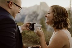 a woman holding a coffee cup while standing next to a man in a suit and tie