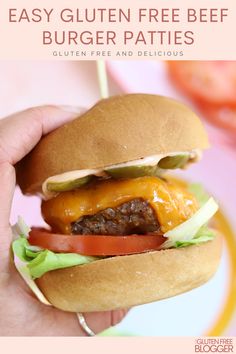 a hand holding a cheeseburger with lettuce and tomato