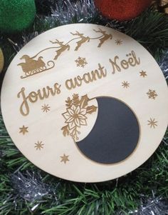 a wooden ornament with the words jesus awaits noel on it's side