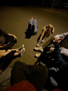 several people sitting on the ground with their feet up