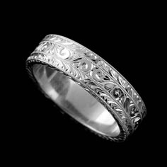 a wedding ring with filigrees and scrolls on the side, in white gold