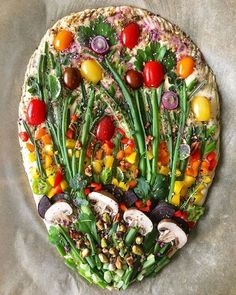 a pizza topped with lots of different types of veggies on top of it