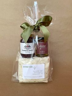 a gift basket with cheese and jams wrapped in plastic