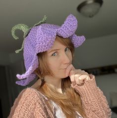 a woman wearing a purple knitted hat with an octopus on it's brim