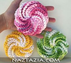 three crocheted washcloths in different colors are being held by someone's hand