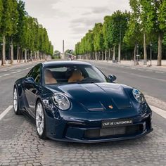 a blue sports car is parked on the street