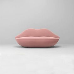 a pink lip shaped object sitting on top of a white floor next to a wall