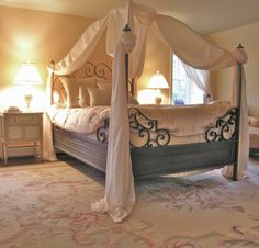 a bedroom with a canopy bed and two lamps