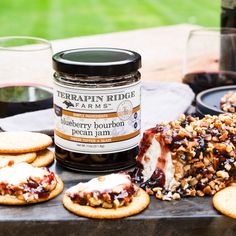 there is a jar of jam next to some crackers and cookies on the table