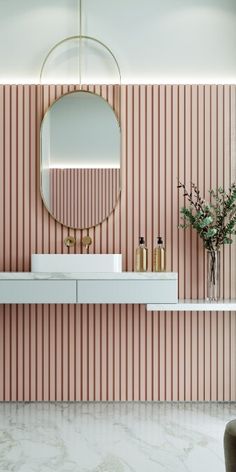 a bathroom with pink and white stripes on the wall, two sinks and a round mirror