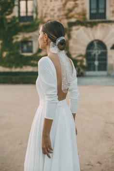 the back of a woman's wedding dress with pearls on it