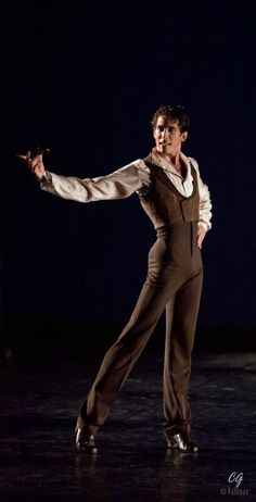 a man in a brown suit and white shirt is dancing