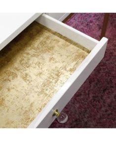 a drawer is open on the carpeted floor in front of a red area rug