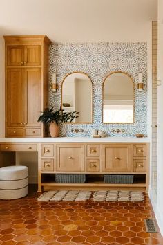 a bathroom with an orange tiled floor and wooden cabinetry, along with two mirrors on the wall