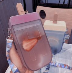 a person holding up a plastic container with strawberries in it and a lemon slice inside