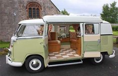 an old vw bus is parked in front of a church with its doors open