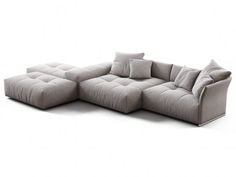 a large gray couch with pillows on it's back and side facing the camera