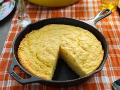 a cake in a skillet on a table with plates and utensils next to it