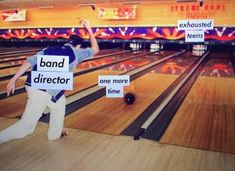 a man holding up signs in front of bowling pins