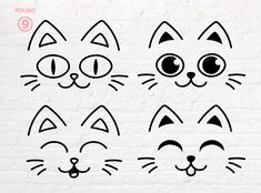 four cat faces drawn on a white brick wall