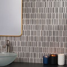 a bathroom with a sink, mirror and candles on the counter next to each other