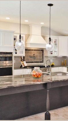 a kitchen with marble counter tops and an island in front of the stove top oven