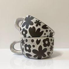 two cups with black and white designs on them