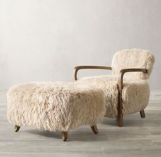 a sheepskin chair and footstool are shown in an empty room with wood flooring