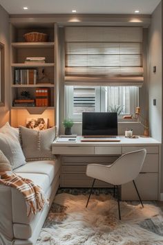 a white couch sitting under a window next to a desk with a computer on it