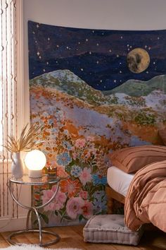 a room with a bed, night sky and flowers painted on the wall behind it