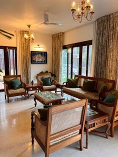 a living room filled with lots of furniture next to a window covered in drapes