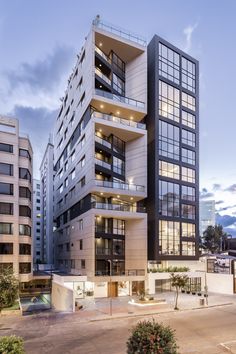 an apartment building with many windows and balconies on the top floor is lit up at night