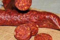 several sausages are on a cutting board with a knife